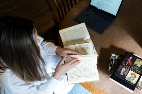 Maura Campbell reading books on a table